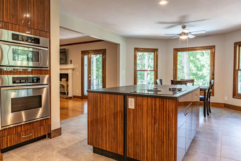 A sleek kitchen with a central island, stainless steel appliances, and floor-to-ceiling windows that invite natural light into the space.