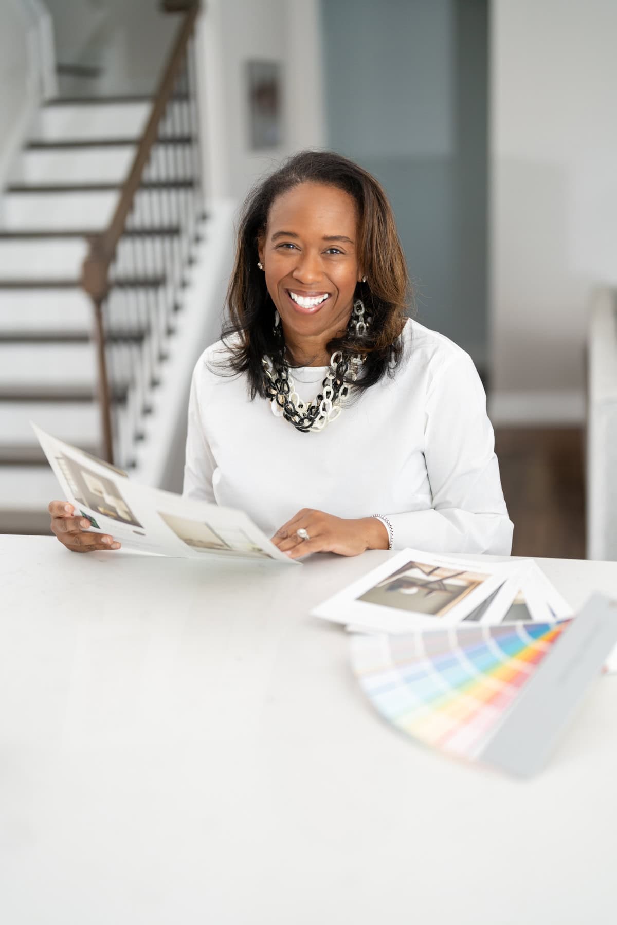 a woman smiling at a table with a paper